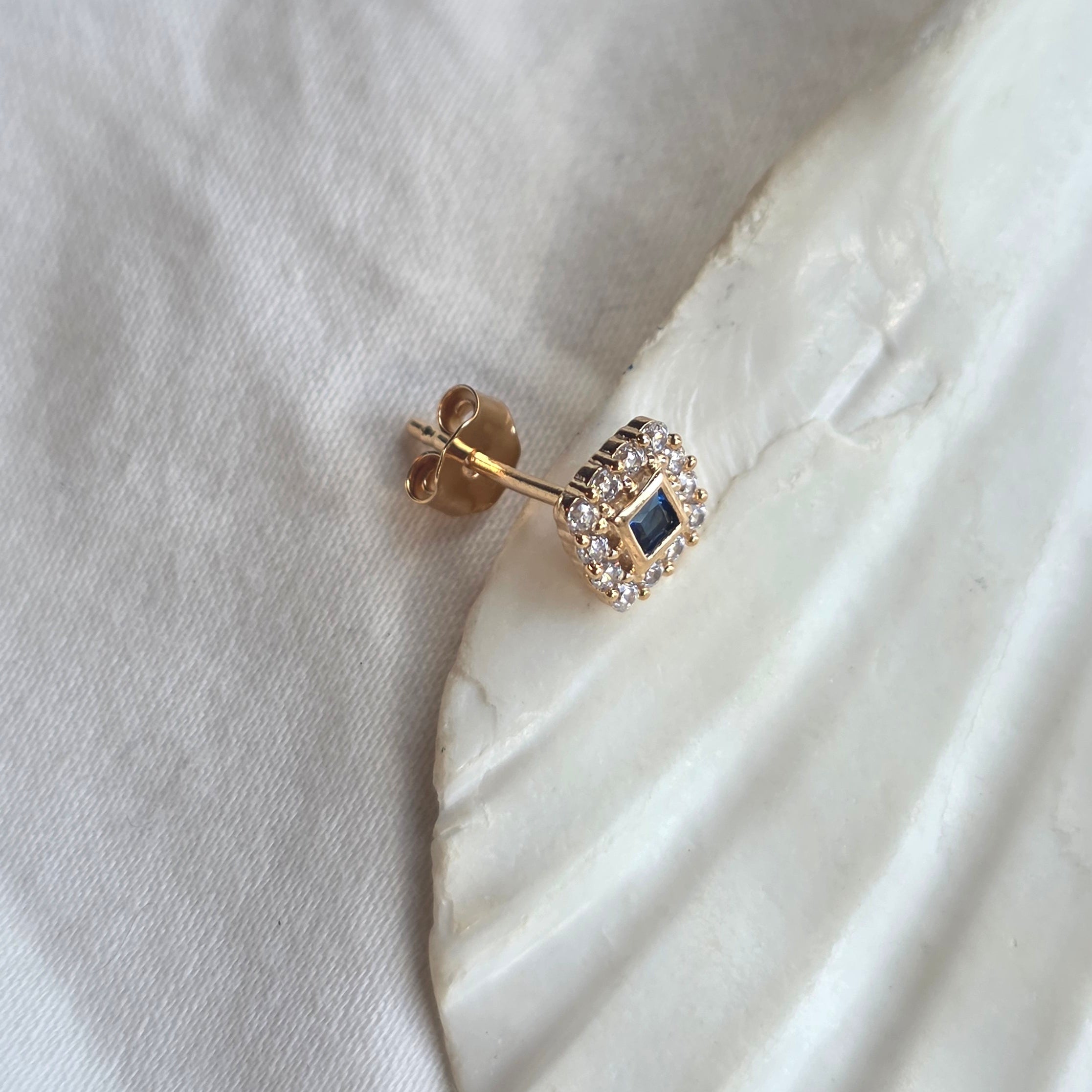 Composition d'oreille avec Raven, touche de bleu au milieu de bijoux dorés