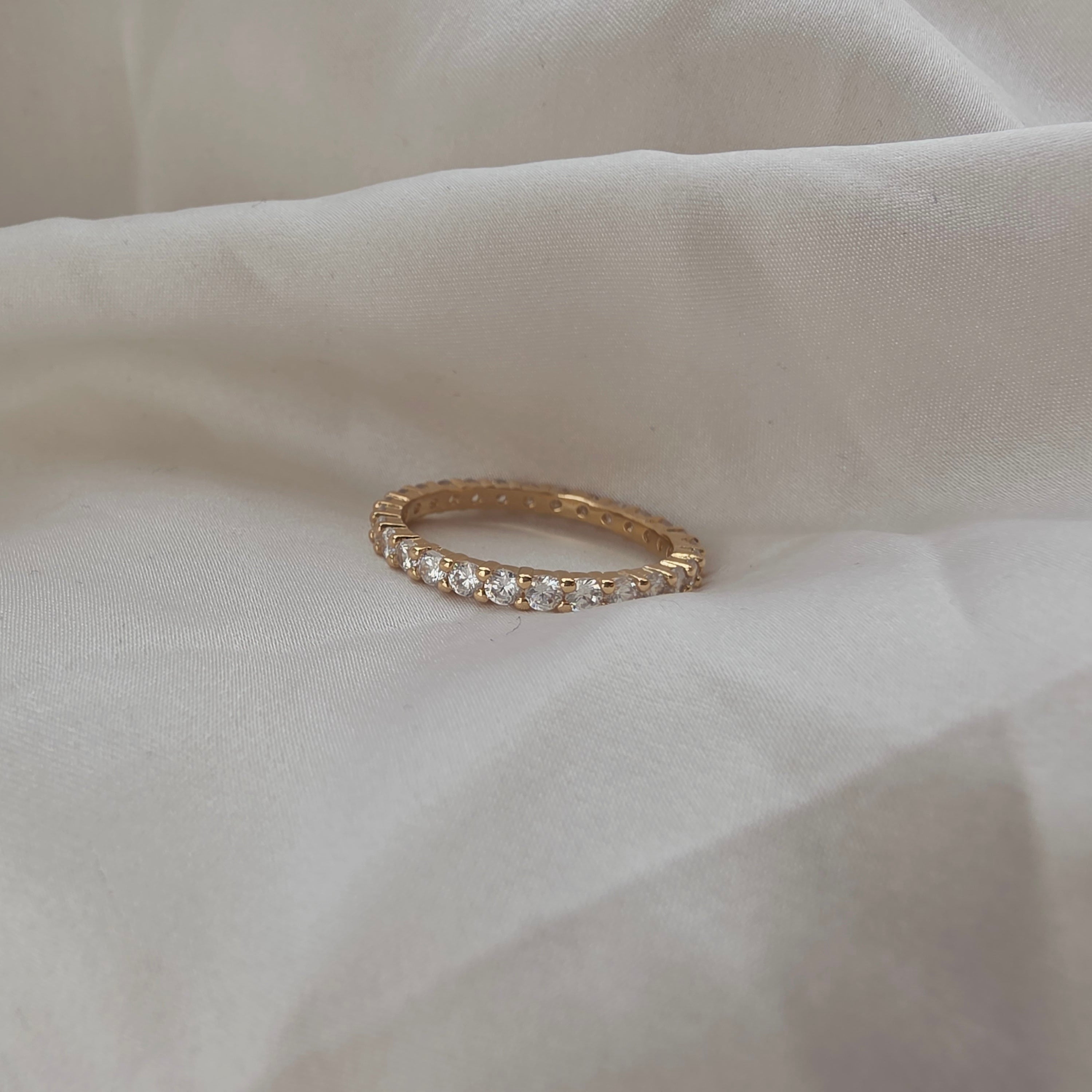 Bague dorée avec pierres brillantes serties