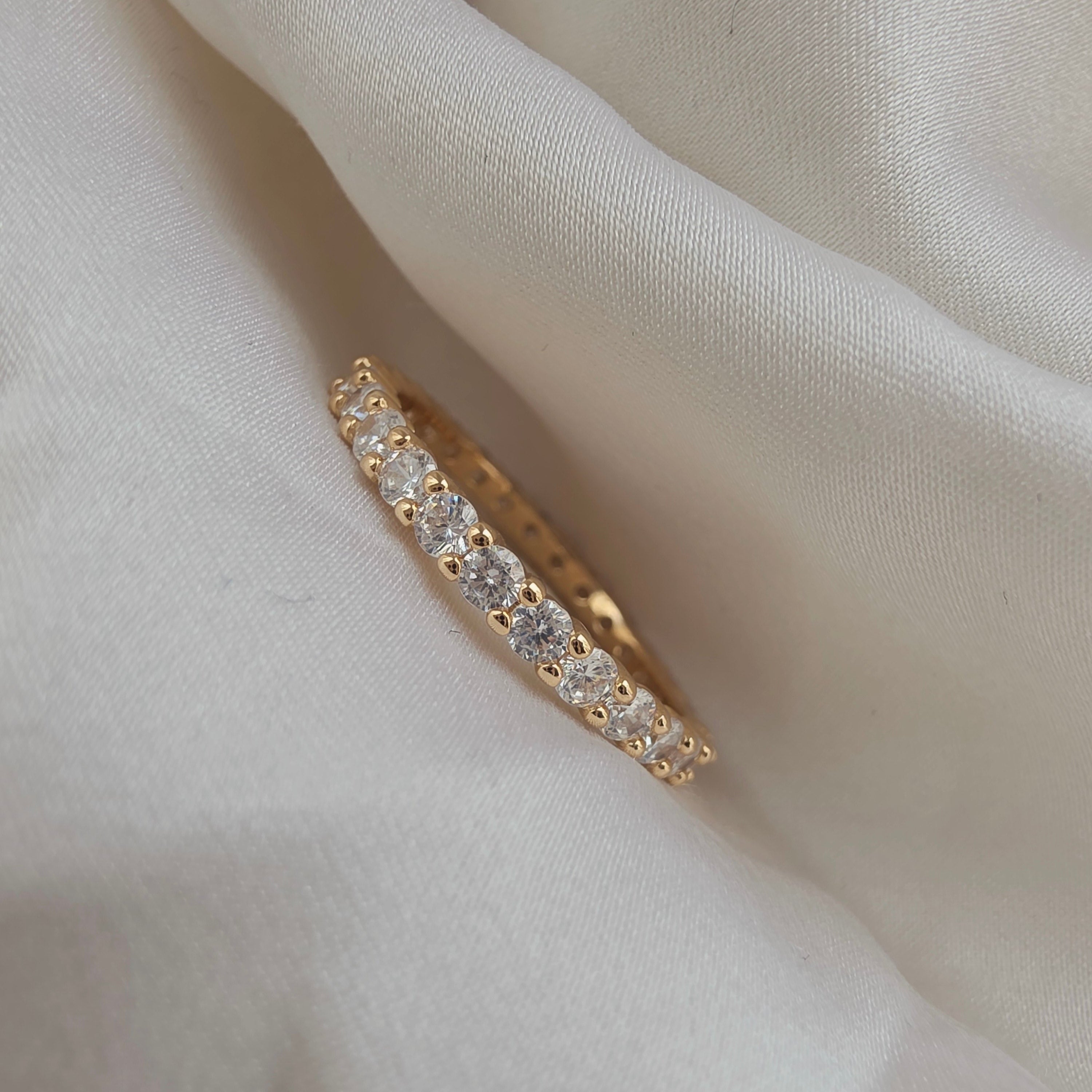 Bague dorée avec pierres brillantes serties