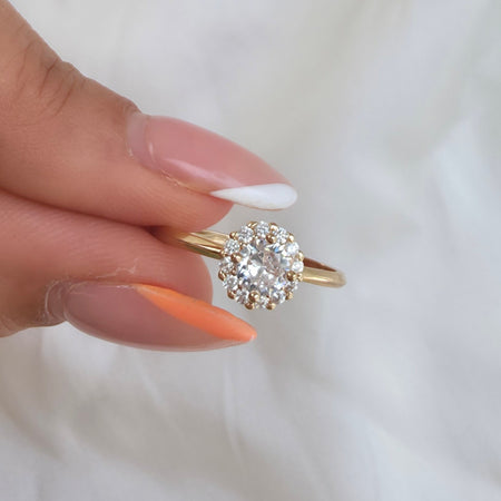 Bague dorée avec pierre centrale scintillante 