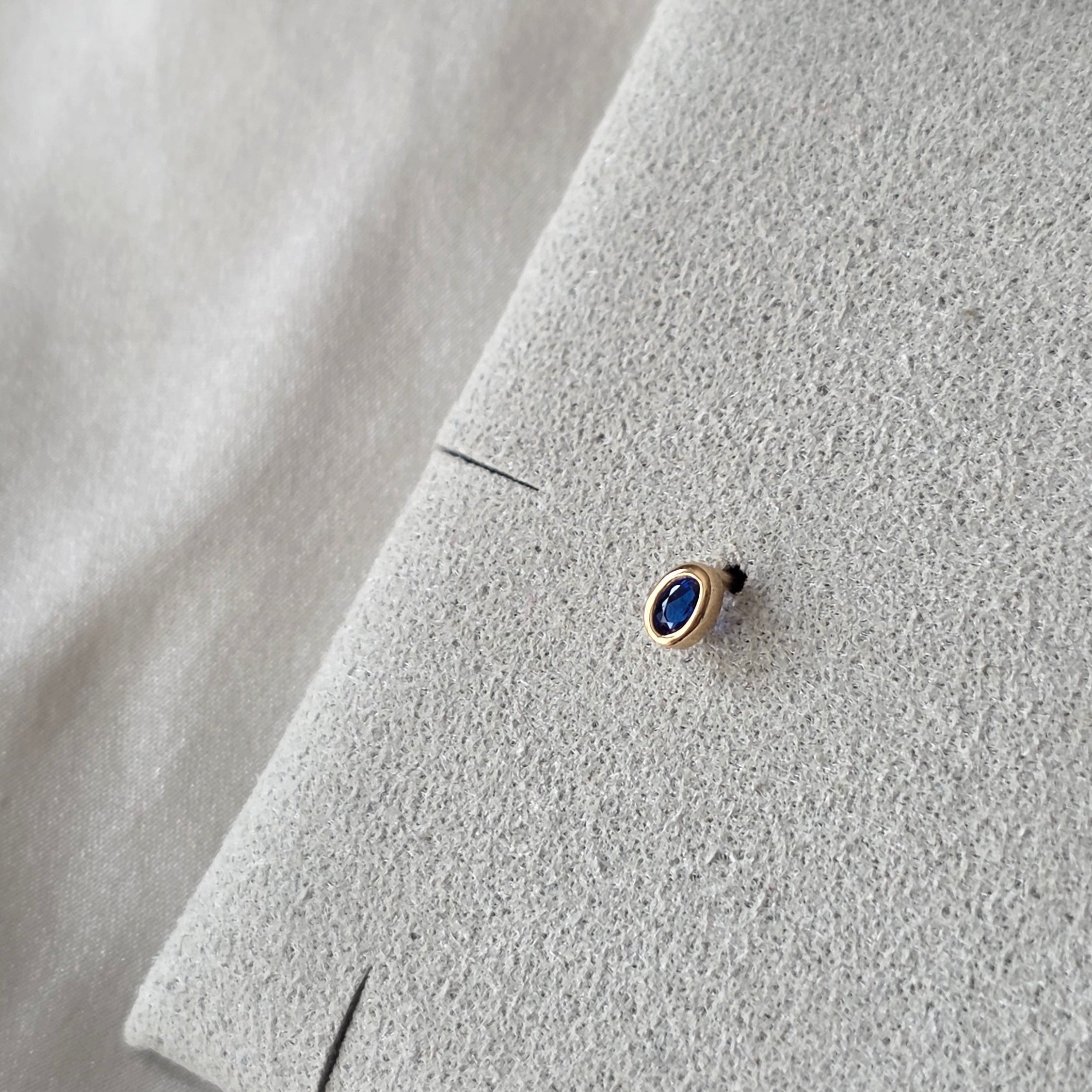 Oreille ornée de la puce Dorine, bleu profond et contour doré