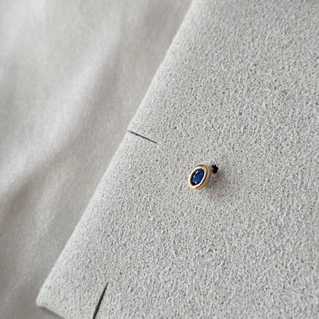 Oreille ornée de la puce Dorine, bleu profond et contour doré