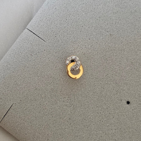 Puce d'oreille Carelle posée à plat, deux anneaux dorés entrelacés vus de face