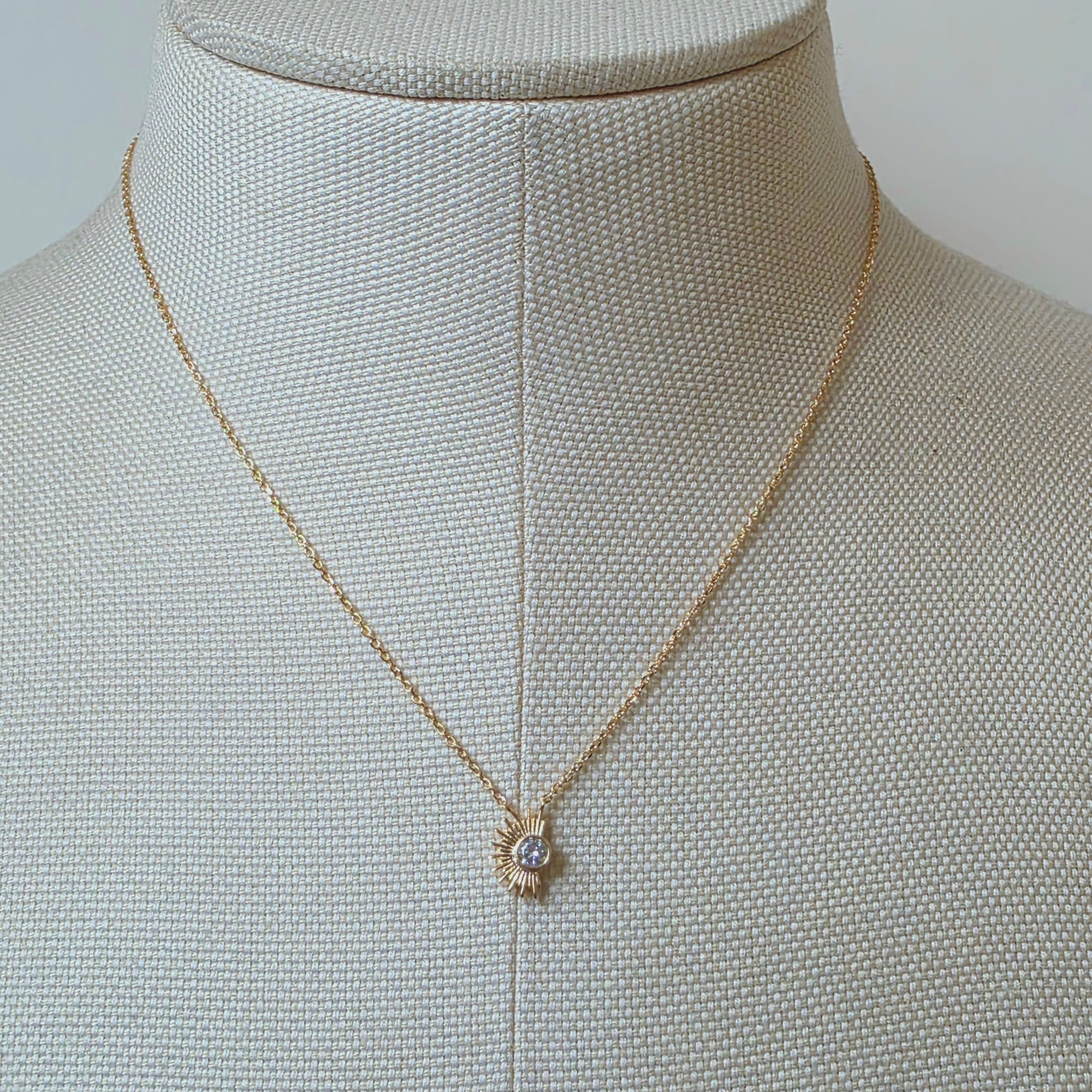 Vue rapprochée du bijou Orphé en métal doré et cristal, bijou inspiré de la lumière et de l’énergie solaire.