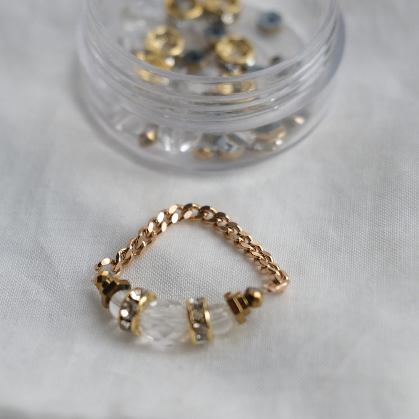 Bague Signature en cristal de roche et hématite portée à la main, bijou ajustable élégant.