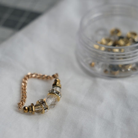 Détail de la bague Signature avec pierres naturelles sur doigt féminin.