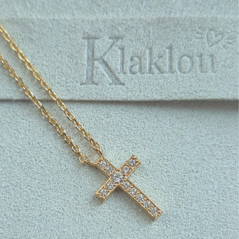 Détail du pendentif en forme de croix scintillante, bijou lumineux et raffiné