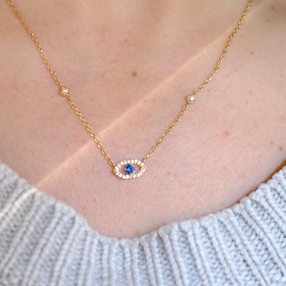 Collier doré avec œil bleu central protecteur et cristaux brillants, bijou fait main en acier inoxydable.