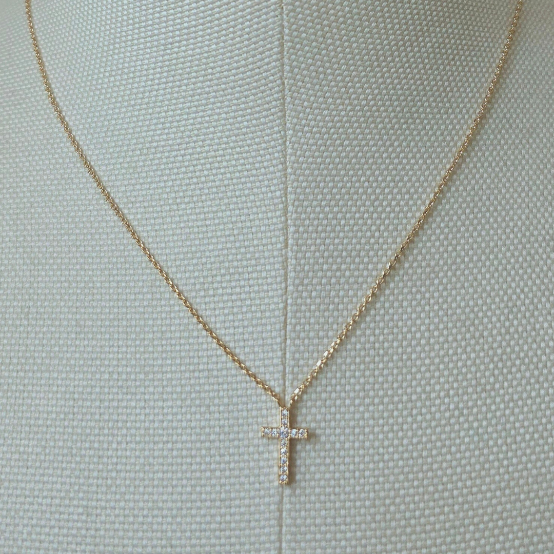 chaîne fine et les reflets dorés du collier croix