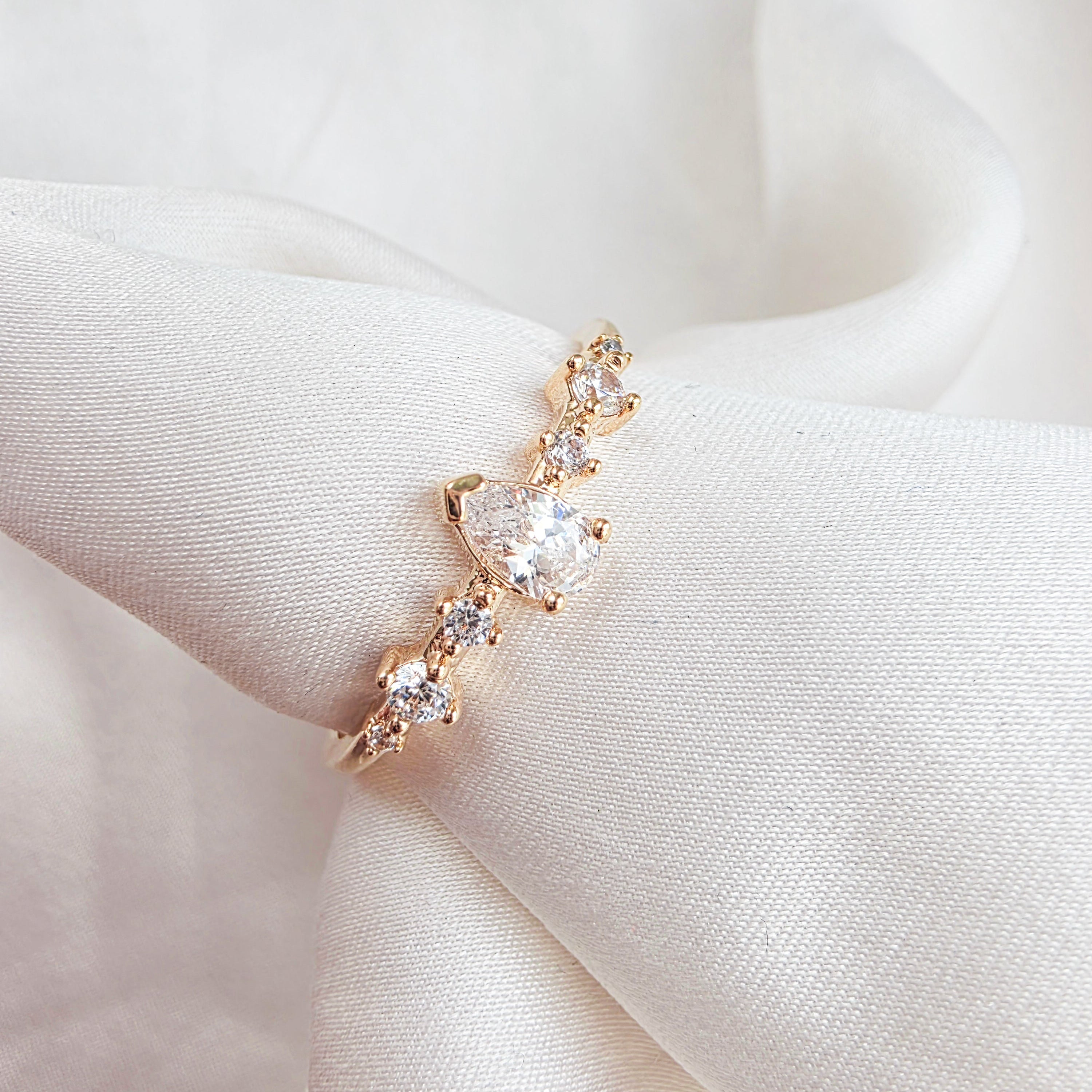 Bague fine dorée avec pierres brillantes sur fond neutre