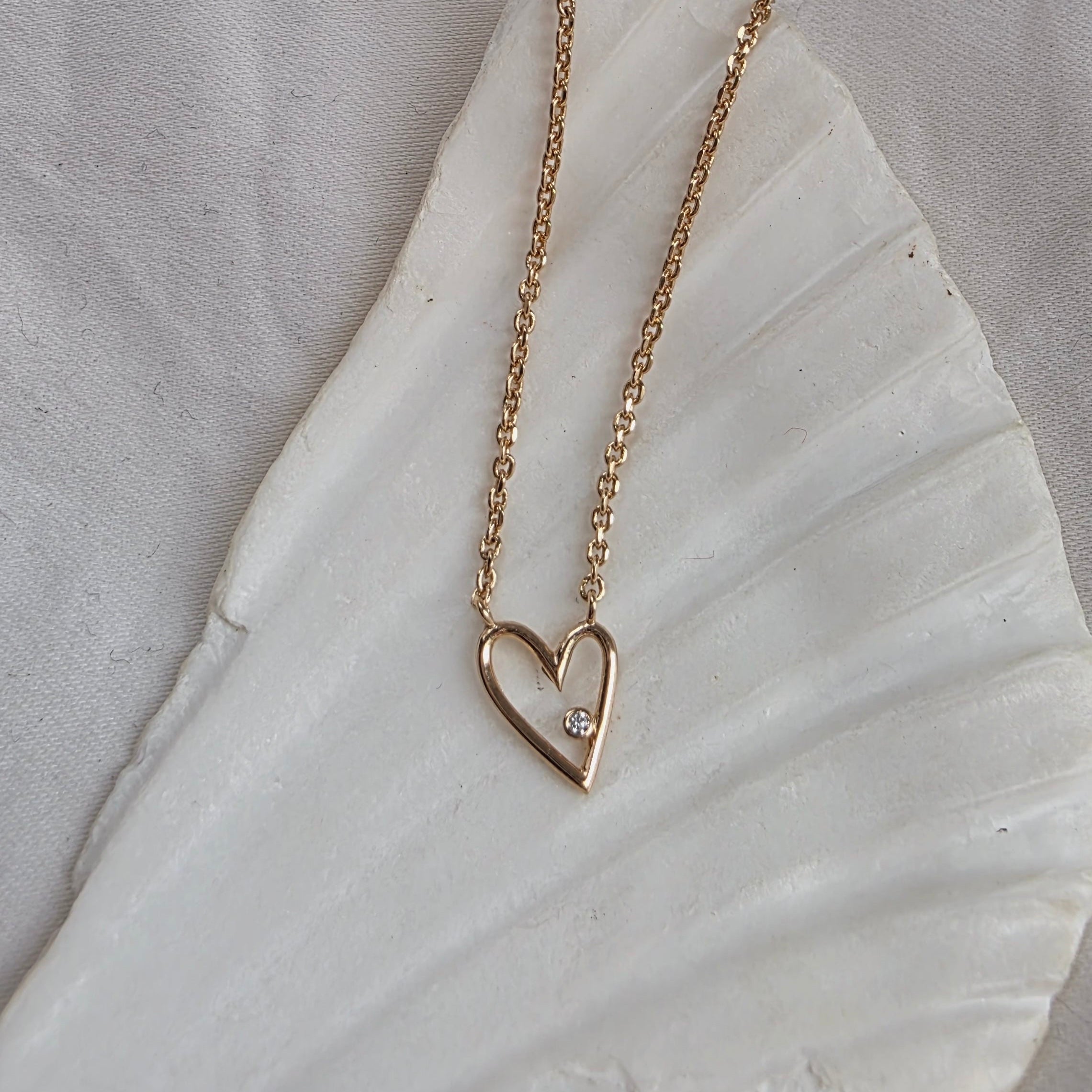 Détail du collier romantique Cora sur fond coquillage